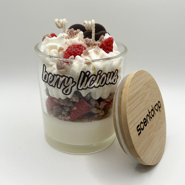 Scented candle with fruit toppings and wooden lid on a white background