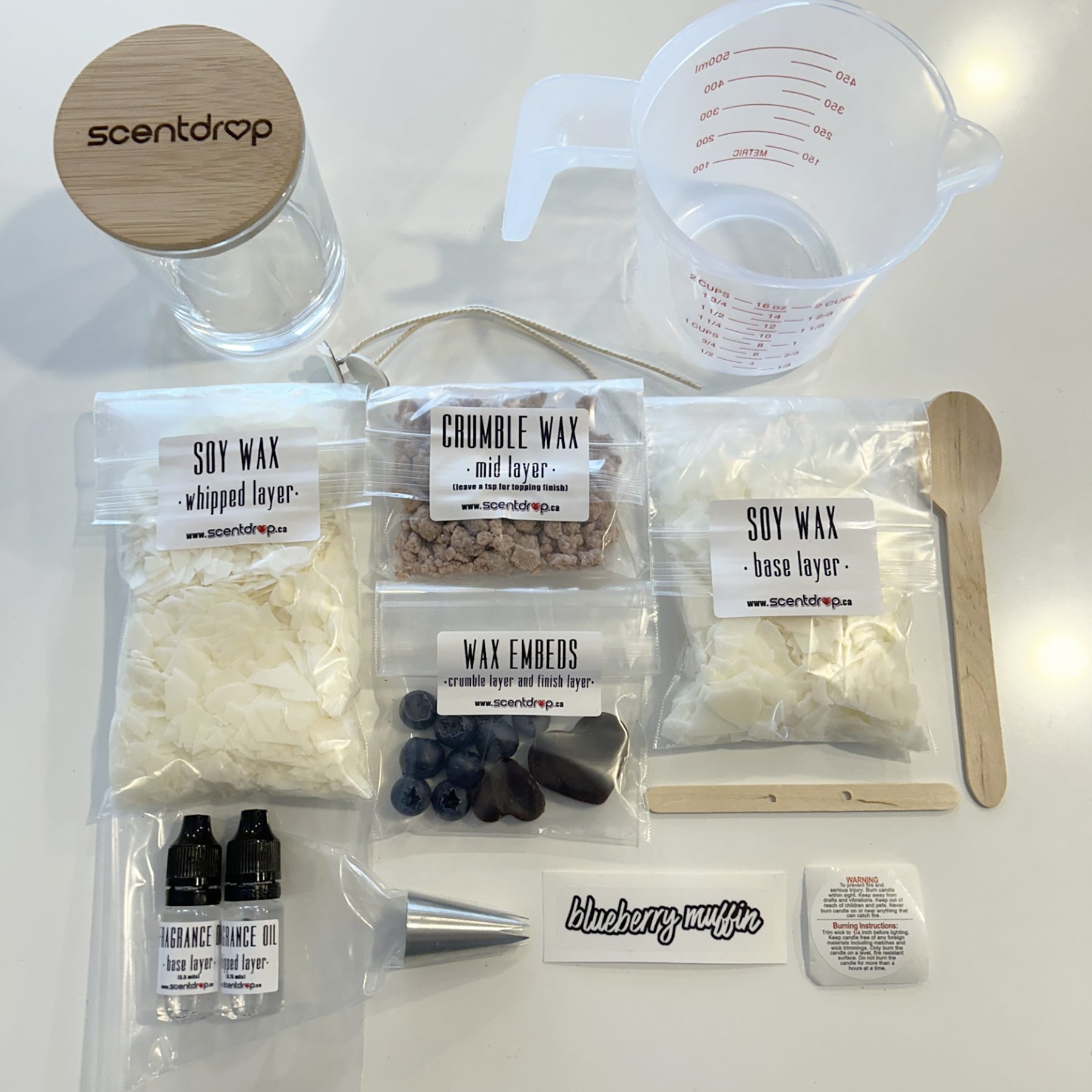 Wax crafting kit with scented wax, embeds, and measuring tools on a white surface.