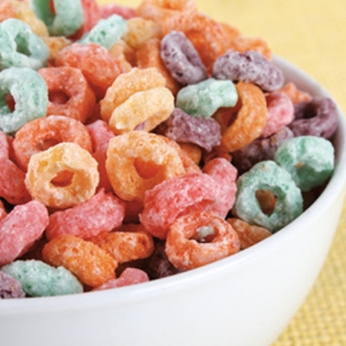 Assorted colorful cereal in a bowl on a yellow background