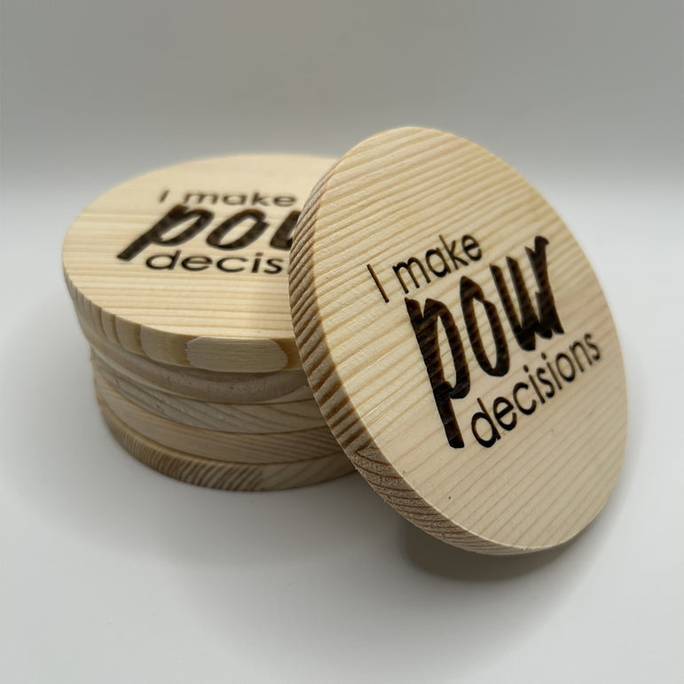 Wooden coasters with 'I make pow decisions' text on a white background