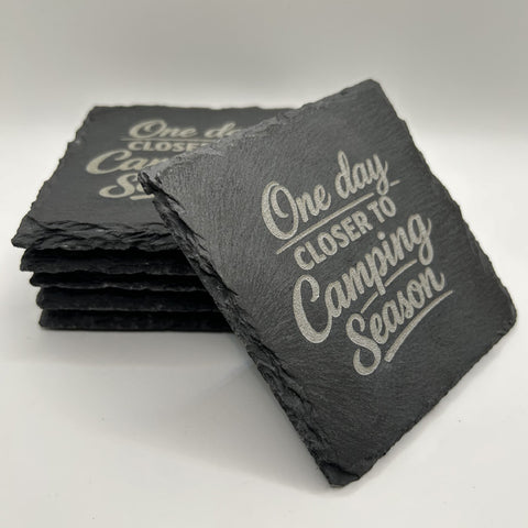 Set of slate coasters with 'One day closer to Camping Season' text on a white background