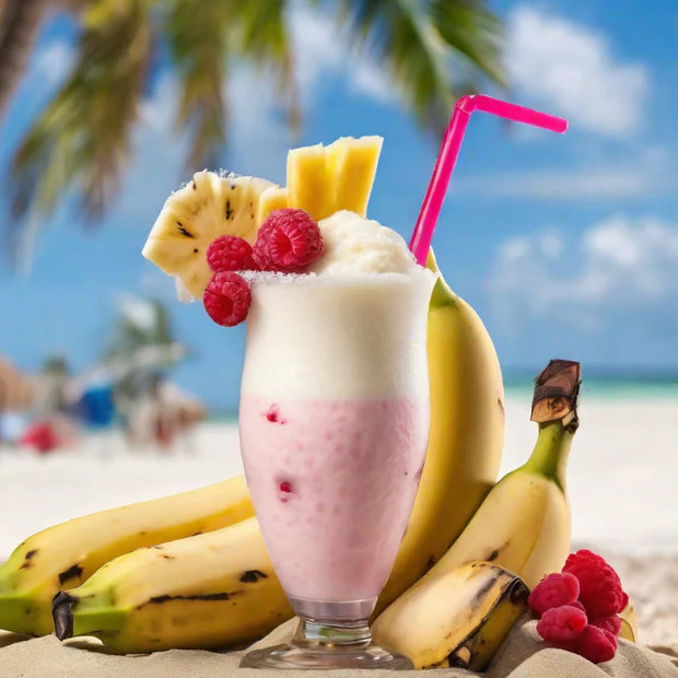 Fruit shake with bananas, raspberries, and a pink straw on a beach.