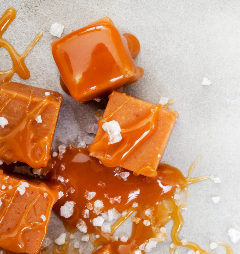 Caramel squares with sea salt on a light gray background