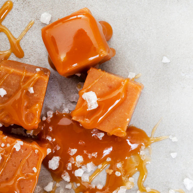 Caramel squares with sea salt on a light gray background