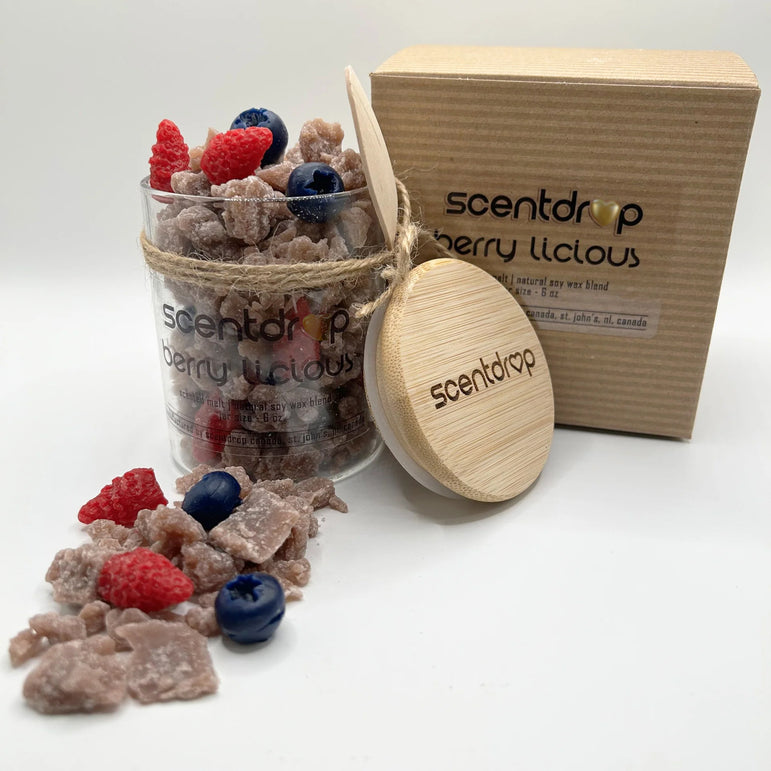 Scentdrop Berry Licious bath salts in a clear glass jar with a bamboo lid and wooden spoon, shown next to its kraft paper box on a white background.
