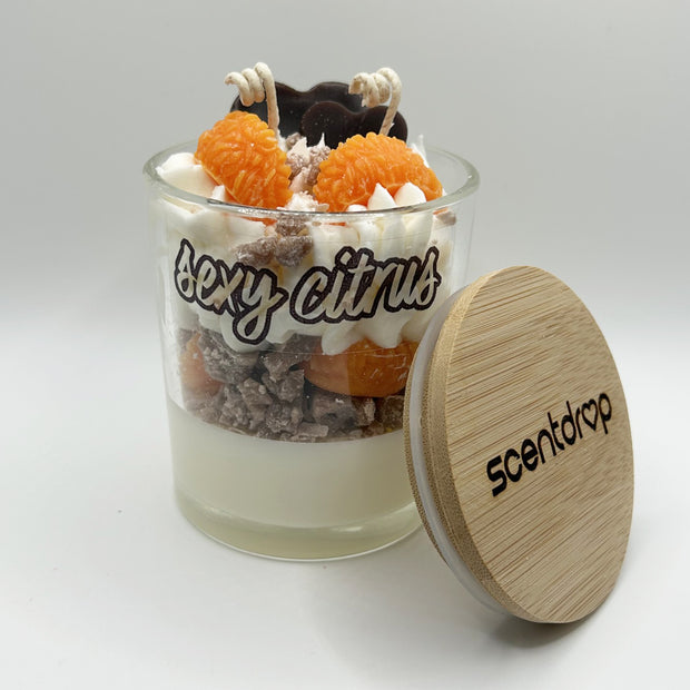Scented candle with decorative elements and wooden lid on a white background