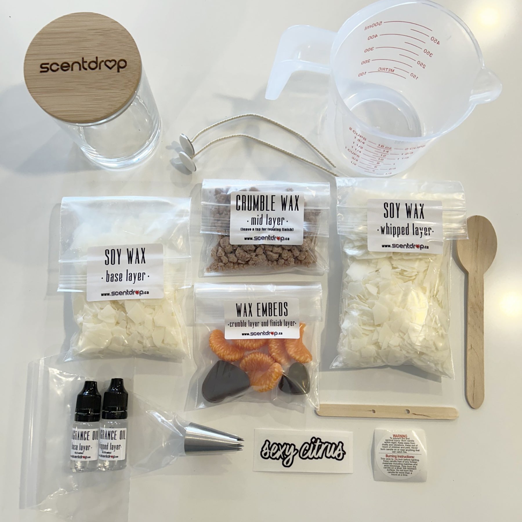 Wax crafting kit with various components on a white surface, featuring the brand 'scentdrop'.
