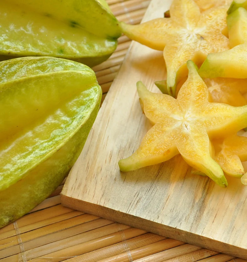 Starfruit and aloe laid on a wooden cutting board