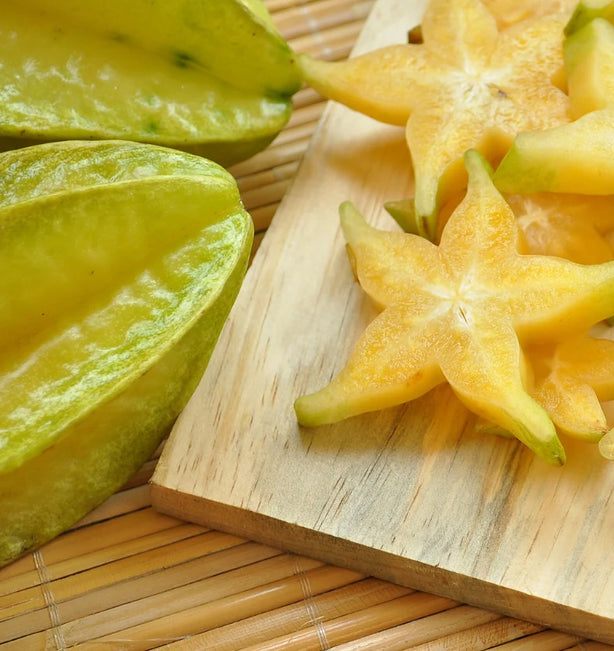 Starfruit and aloe laid on a wooden cutting board