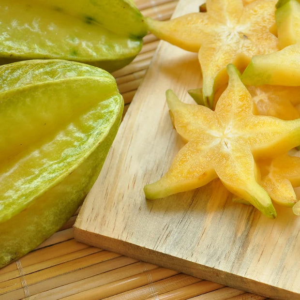 Starfruit and aloe laid on a wooden cutting board