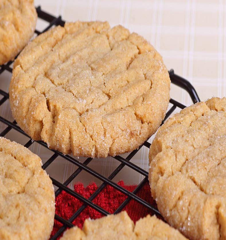 Peanut butter cookies on a cooling rack with a red cloth underneath