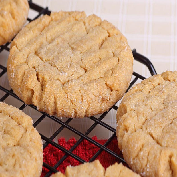 Peanut butter cookies on a cooling rack with a red cloth underneath