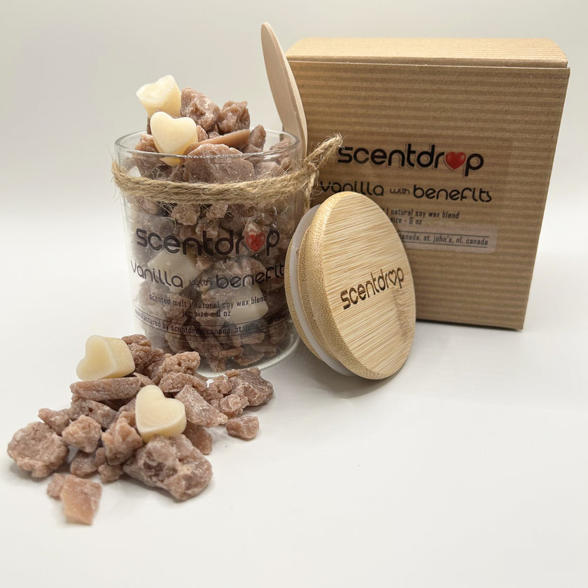 Scented wax melts in a glass jar with wooden lid and packaging on a white background