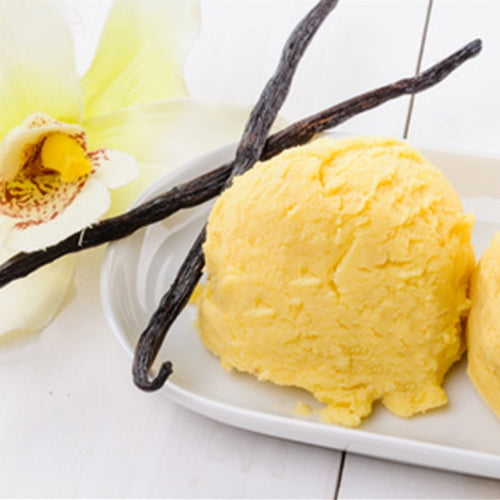 Vanilla ice cream with vanilla beans and a vanilla flower on a white plate.